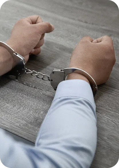 selective-focus-shot-male-hands-handcuffs-wooden-table (1) 1